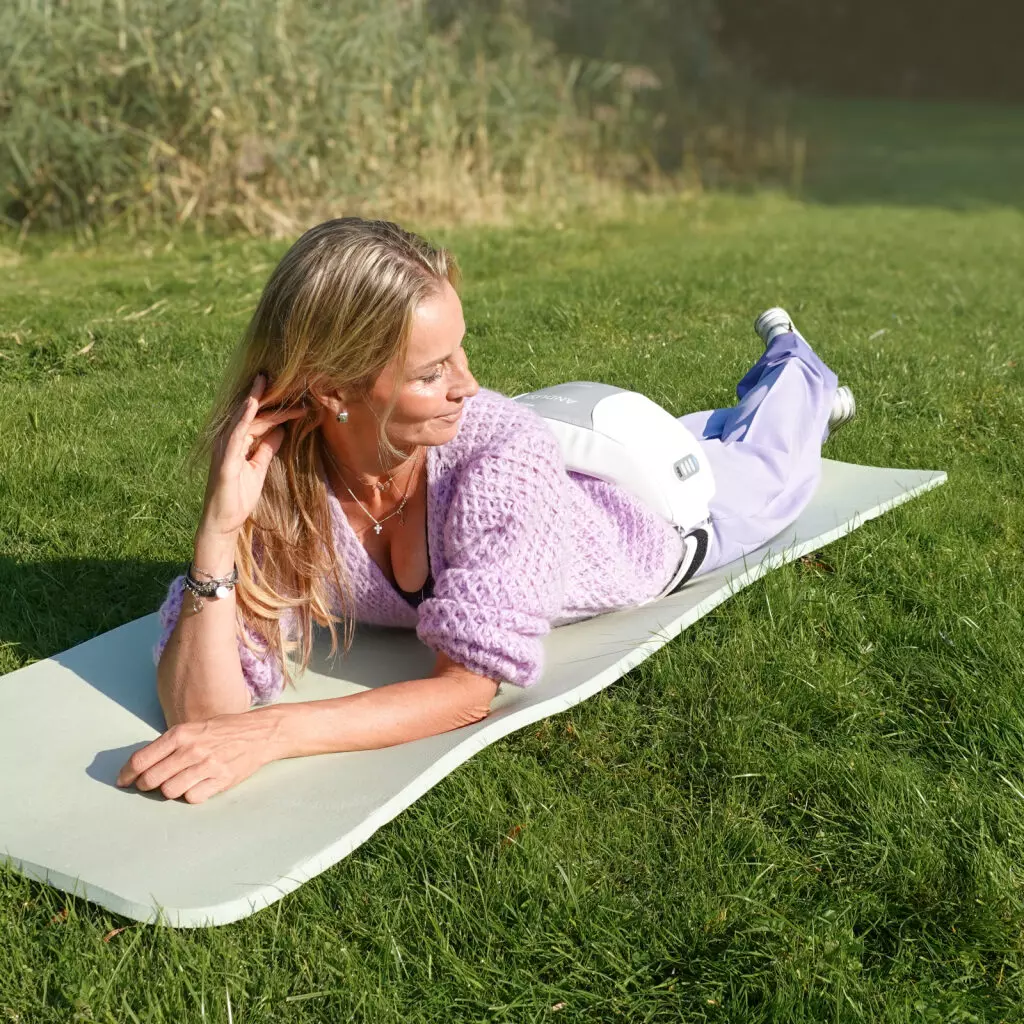Anduslim_Andullation_Schmerztherapie_Bauchgurt_Massage_Ruecken, Yoga mat, Exercise, Sportswear, Lila Pullover, Frau auf Matte